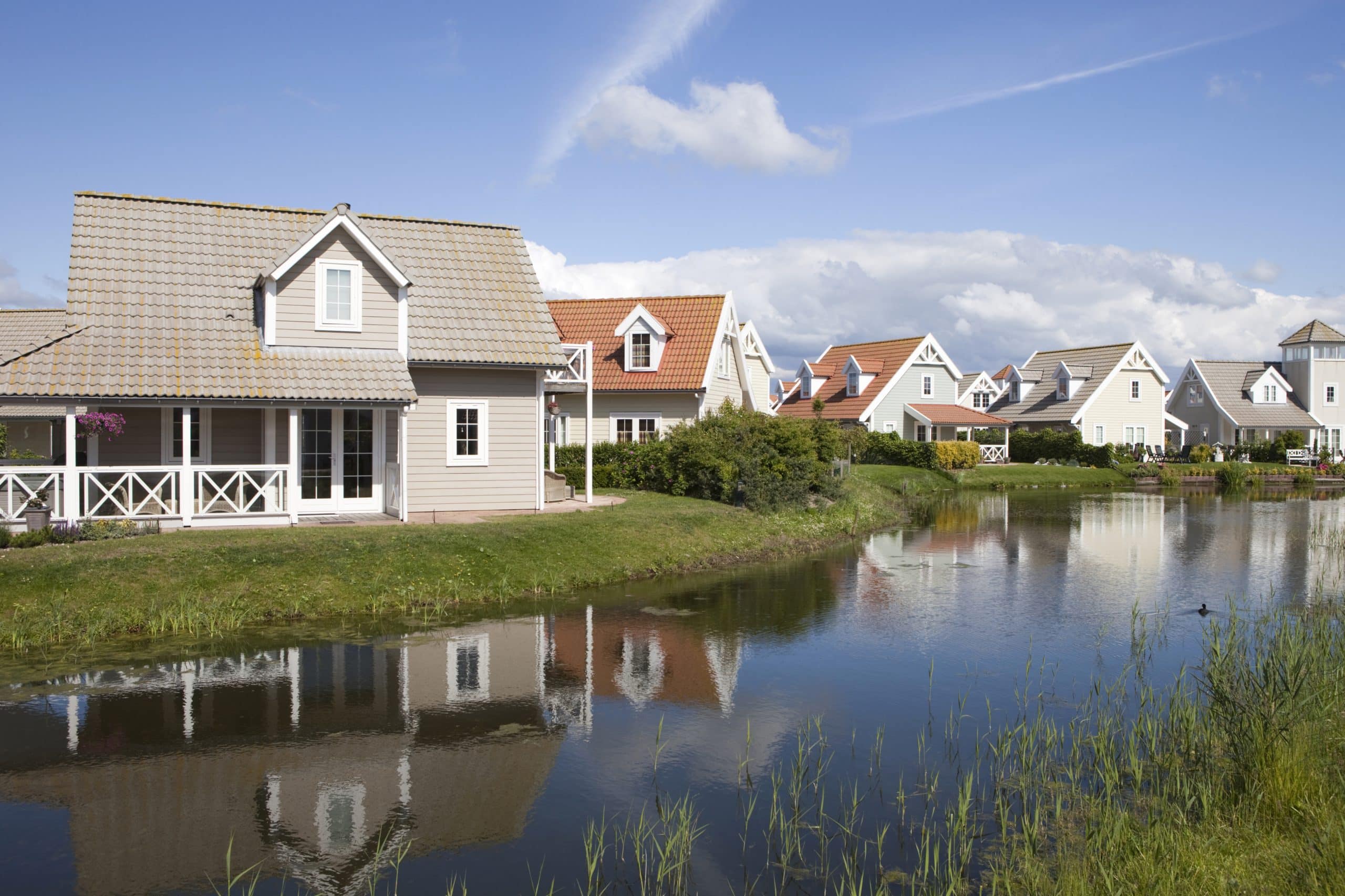 "reflection of some Scandinavian style holiday houses in the water on a clear day; 's-Gravenzande, Netherlands"