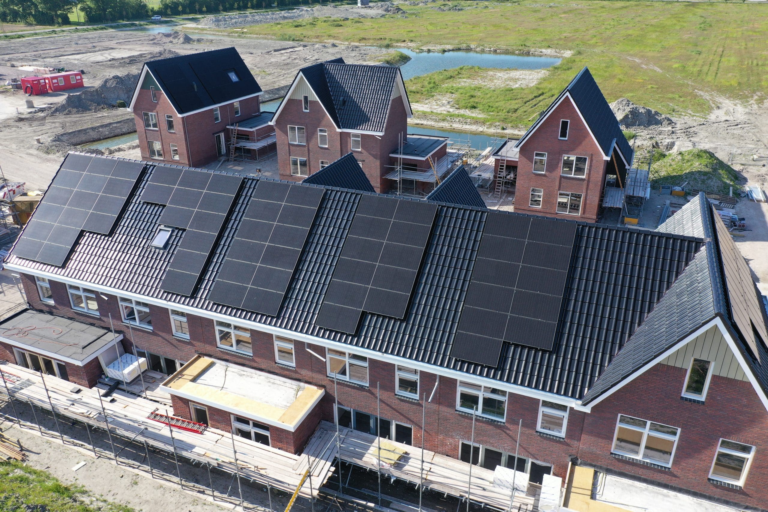 newly built well-insulated houses with black solar panels and heat pumps for economical energy consumption, this is the future for many homes. drone view